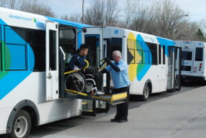 Personne en fauteuil roulant descendant d'un mini-bus de la STM