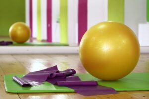 Photographie d'un ballon jaune et tapis d'exercices.
