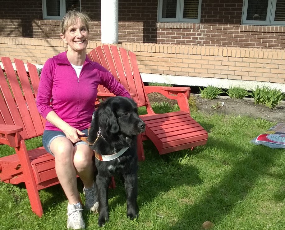 Photo de France Poulin assise à l'extérieur avec son chien-guide Onyx