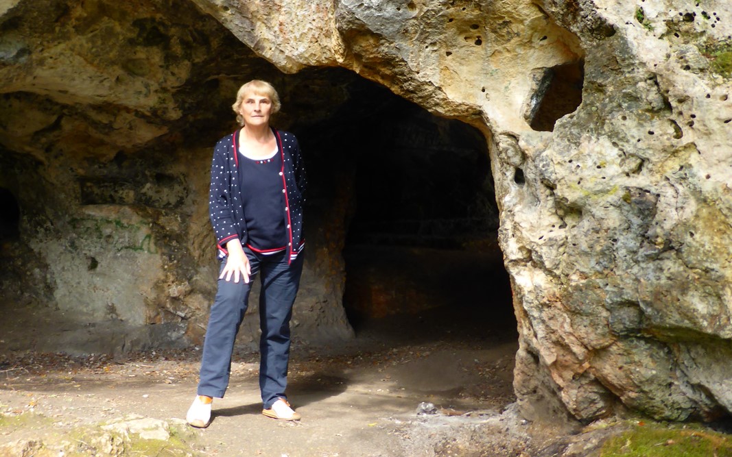 Photo de Michelle Brûlé se tenant debout devant une grotte.