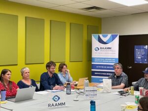 Martine Bedard, Pascale Dussault, le président d'assemblée et des membres, avec la bannière du RAAMM en arrière-plan et logo.