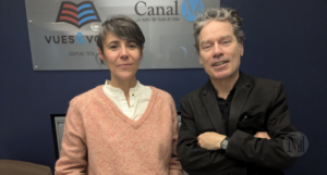 Photographie d'Alain Renaud avec Enora Rivière devant une affiche de Canal M.