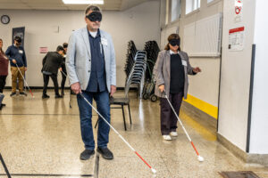 Photographie de candidats aux élections de Laval réalisant un parcours sous bandeau, atelier animé par le RAAMM.